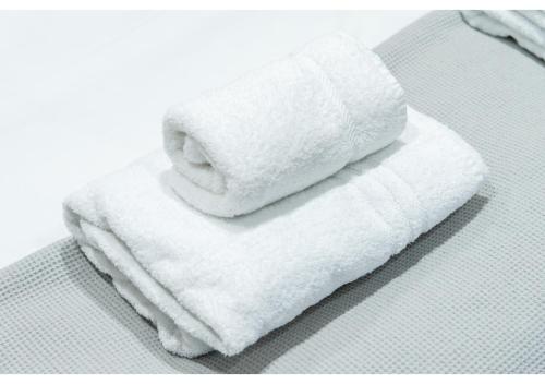 two white towels sitting on top of a bed at Classic 2BD Flat in Chelmsford in Chelmsford