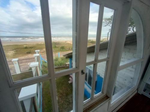 une fenêtre ouverte avec vue sur la plage dans l'établissement Casa beiramar, solar, barulho do mar, pé na areia!, à Xangri-lá