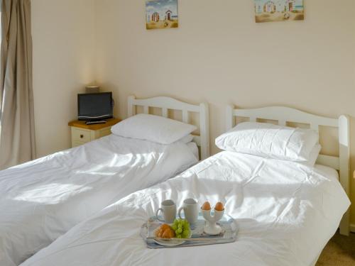 two white beds with a tray of fruit on them at Roses Place in Bacton