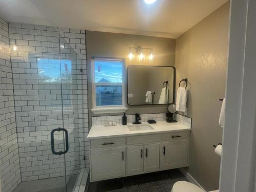 y baño con lavabo, espejo y ducha. en Apt 3 - Roman at High Plains Lodge, en Clayton