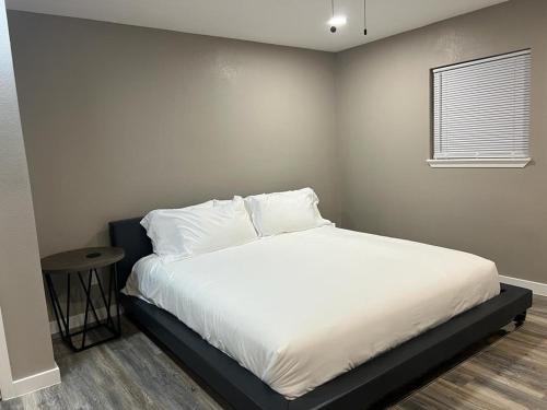 1 dormitorio con 1 cama con sábanas blancas y ventana en Apt 3 - Roman at High Plains Lodge, en Clayton