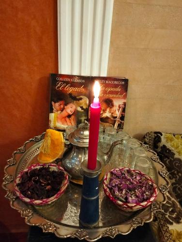 a candle sitting on top of a table with two plates at RIAD GREEN LOTUS in Marrakech