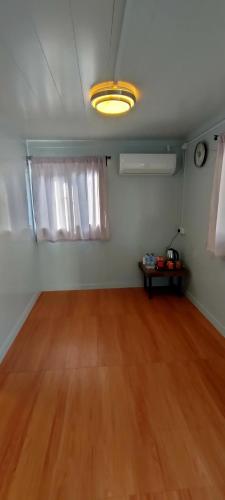 an empty room with a wooden floor and a clock at Guest House Gua Kelam in Kaki Bukit