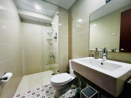 W łazience znajduje się umywalka, toaleta i lustro. w obiekcie Luxury 2BR with Balcony Suite 25 - Pool, City View w mieście Manila