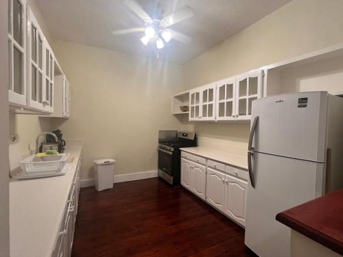 a kitchen with white cabinets and a white refrigerator at Inchcape Seaside Villas in Christ Church