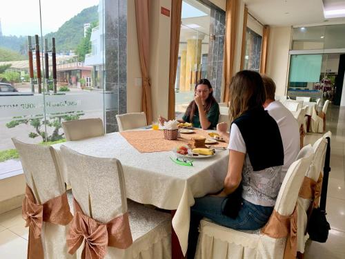 een groep mensen die aan een tafel zitten bij Hung Long Harbour Hotel in Cat Ba