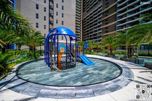 a playground in front of a building with palm trees at The Sóng Luxury Apartment Vung Tau - Tuấn Hoà Homestay in Vung Tau