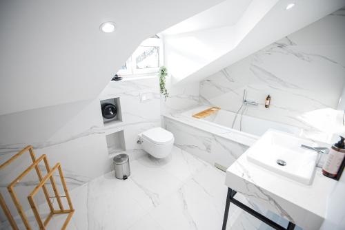 bagno bianco con servizi igienici e lavandino di Leo Luxury Rooms i Apartments a Zenica