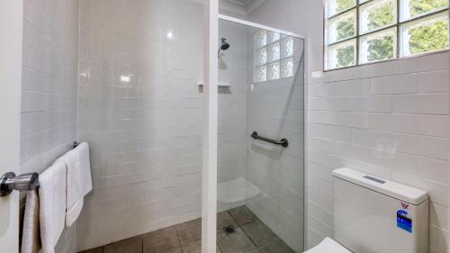 a white bathroom with a shower and a toilet at Riverland Motor Inn in Saint George