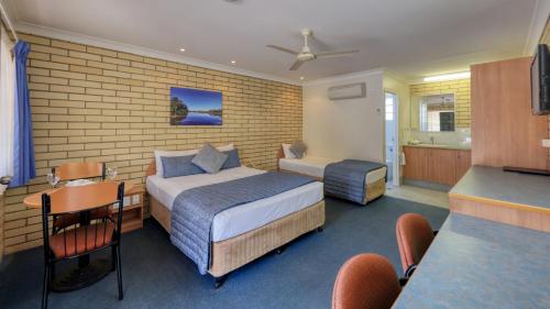 セント・ジョージにあるRiverland Motor Innのベッド2台とキッチンが備わるホテルルームです。