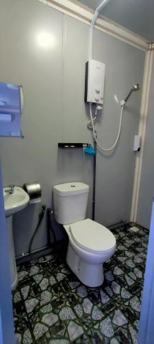 a bathroom with a white toilet and a sink at Guest House Gua Kelam in Kaki Bukit