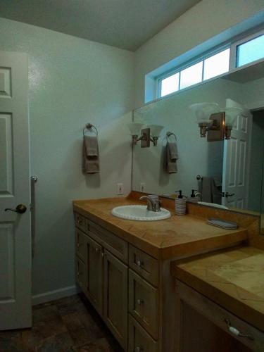 a bathroom with a sink and a large mirror at Riffle Road Ranch in Spirit Lake