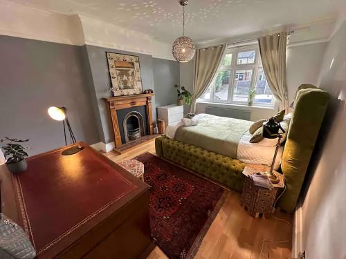 Schlafzimmer mit einem Bett, einem Tisch und einem Kamin in der Unterkunft The Gemstone Manor in Watford