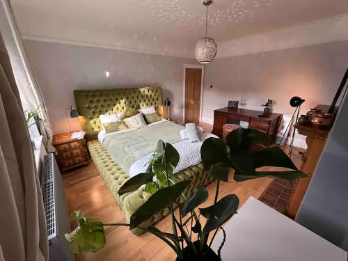 um quarto com uma cama e um vaso de plantas em The Gemstone Manor em Watford