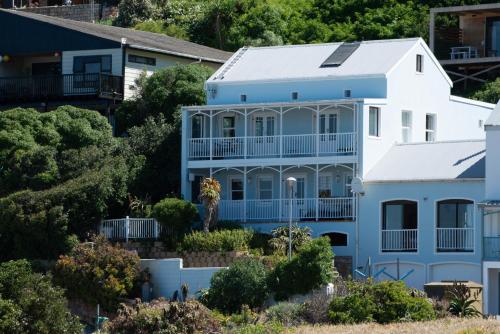 una casa azul y blanca con árboles y arbustos en Beach Haven, en Ciudad del Cabo