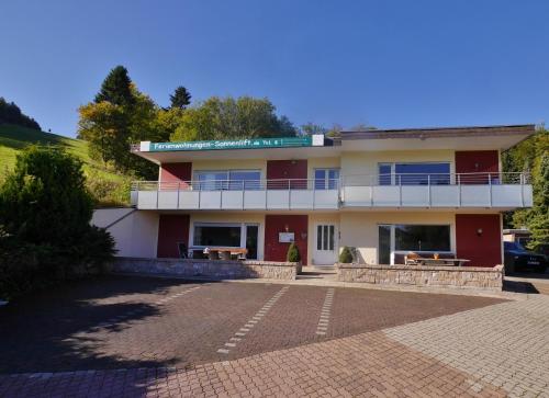 a building with a balcony and a parking lot at Quartier12 "Ski in & Bike out" - Fewo ZEIT in Willingen