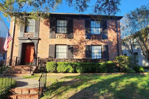 ein Backsteinhaus mit einer Flagge davor in der Unterkunft Secluded English Retreat by Rice, Medical Center & Museum District in Houston