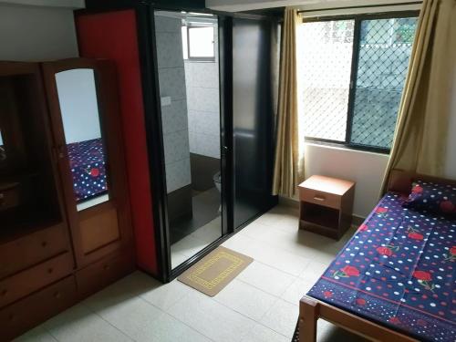 a room with a bed and a door and windows at Barrett Accommodation Budget Rooms in Suva