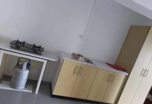a room with two cabinets and a table with a jug at Barrett Accommodation Budget Rooms in Suva