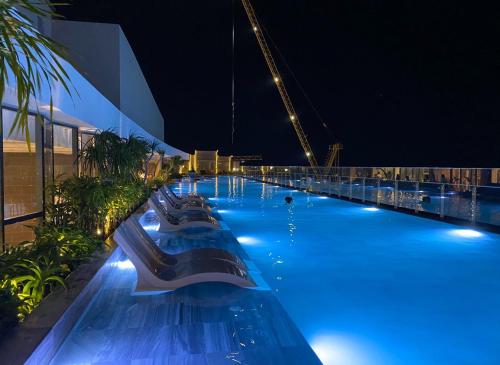 a swimming pool at night with a cruise ship at The Sóng Luxury Apartment Vung Tau - Tuấn Hoà Homestay in Vung Tau