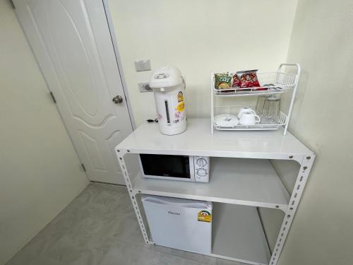 a small white table with a coffee maker on it at Pada Guesthouse Khaoyai in Mu Si
