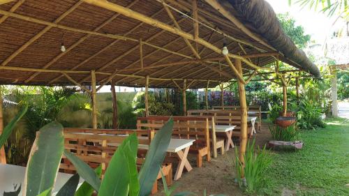 a group of tables and benches under a pavilion at Yayay Siargao in General Luna