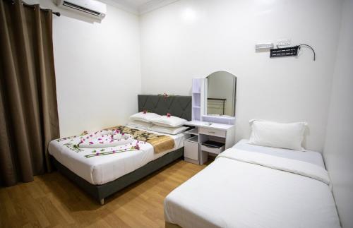 Habitación de hotel con 2 camas y espejo en iHaven Thulusdhoo en Thulusdhoo