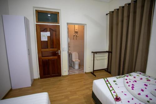 ein Schlafzimmer mit einem Bett und ein Badezimmer mit einem WC in der Unterkunft iHaven Thulusdhoo in Thulusdhoo