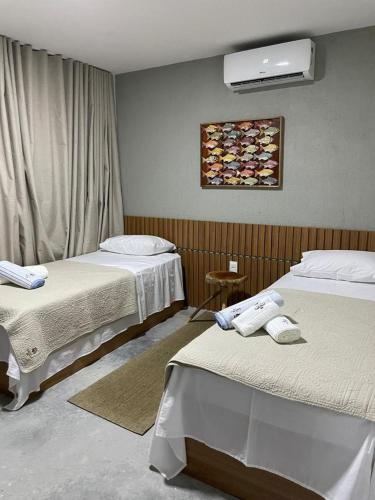 Zimmer mit 2 Betten und Avertisation in der Unterkunft VILA CORALLI CASA 05 in Passo de Camarajibe