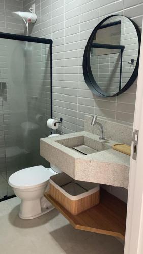 a bathroom with a sink and a toilet and a mirror at VILA CORALLI CASA 05 in Passo de Camarajibe