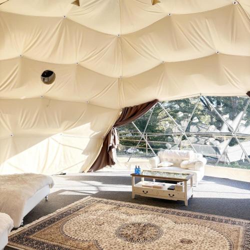 a tent with a bed and a table in a room at グランピング　星が見の杜 in Nakatsugawa