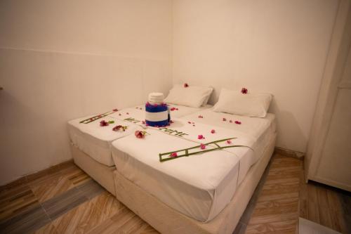 a white bed with flowers and candles on it at iHaven Thulusdhoo in Thulusdhoo