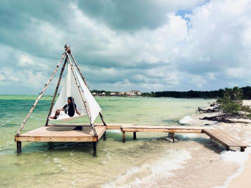 a person in a hammock in the water on the beach at Villas Secreta Beachfront Resort in San Pedro