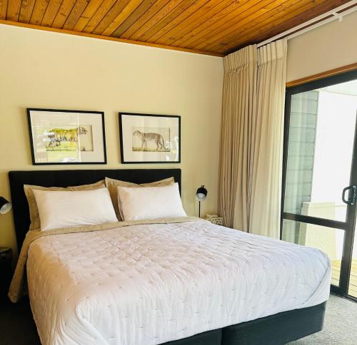 a bedroom with a large bed and a window at The Bay The Beach The Mount The Best in Mount Maunganui