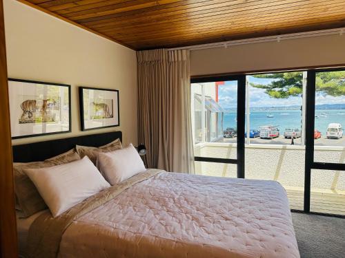 a bedroom with a bed with a view of the ocean at The Bay The Beach The Mount The Best in Mount Maunganui