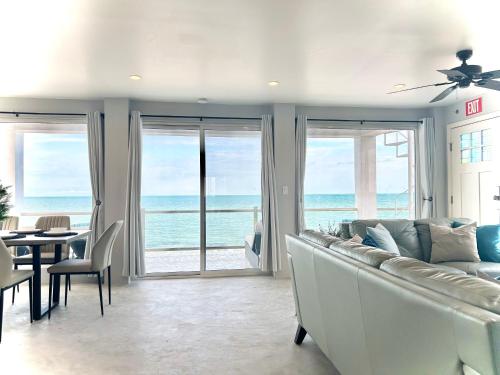a living room with a couch and a view of the ocean at Villas Secreta Beachfront Resort in San Pedro