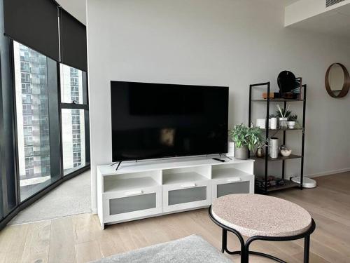 a white entertainment center with a flat screen tv in a living room at Luxury 3 Bed 2 Bath + car park at Melbourne Square in Melbourne