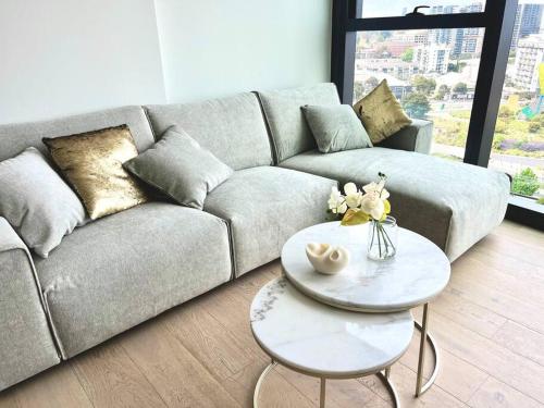 a living room with a couch and a table at Luxury 3 Bed 2 Bath + car park at Melbourne Square in Melbourne