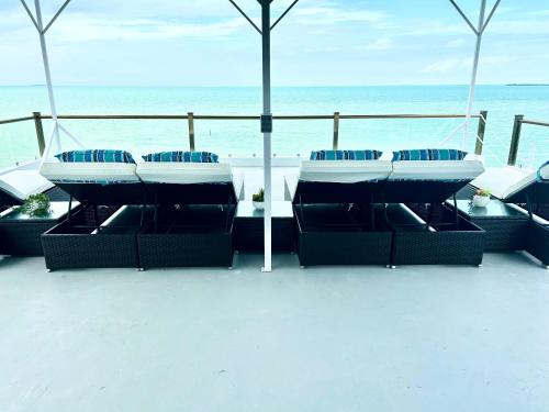a balcony with chairs and a view of the ocean at Villas Secreta Beachfront Resort in San Pedro