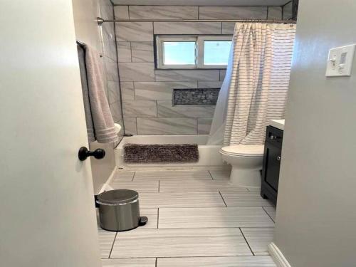 a bathroom with a tub and a toilet and a window at Quiet & Cozy home near Hospitals in Cleveland