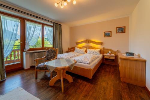 a bedroom with a bed and a table and a desk at Ferienwohnungen Schweiger in Ruhpolding