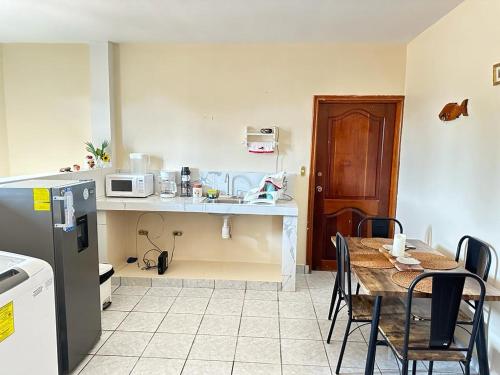 a kitchen with a table with chairs and a microwave at Vacation Home La Ceiba in La Ceiba