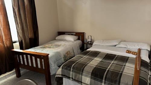 um quarto com 2 camas e uma janela em Vacation Home La Ceiba em La Ceiba