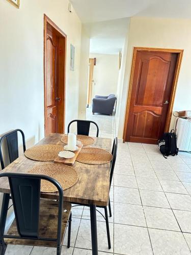 a wooden table with chairs and a wooden door at Vacation Home La Ceiba in La Ceiba