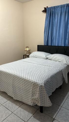 a bedroom with two beds and a blue curtain at Vacation Home La Ceiba in La Ceiba