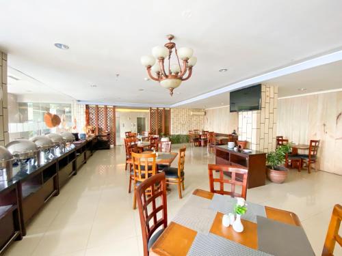 a dining room with tables and chairs and a restaurant at Vrata Hotel Yogyakarta in Kalasan