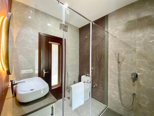 a bathroom with a sink and a shower at Vastu Serene Studio Apartment in Dehradun