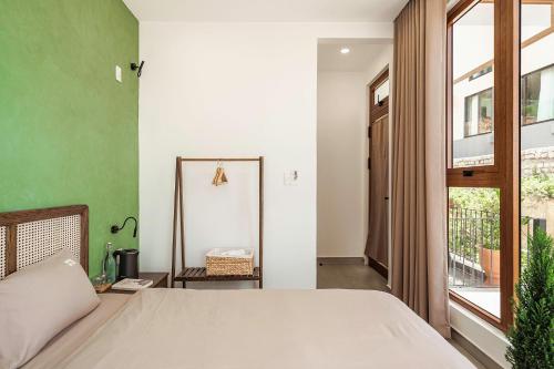 a bedroom with a bed and a green wall at Miền Sương Khói - Home & Café in Khu Chi Lăng
