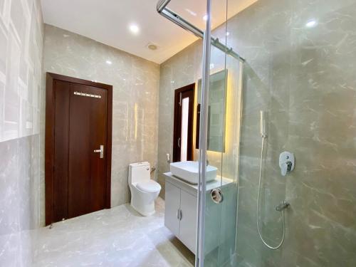 a bathroom with a toilet and a glass shower at Vastu Serene Studio Apartment in Dehradun
