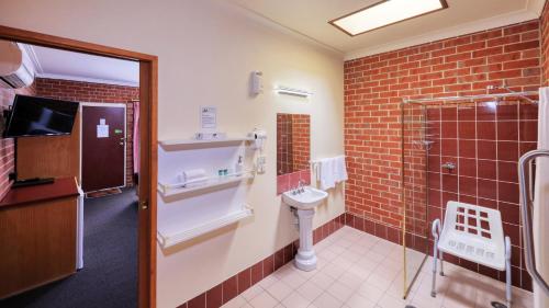ein Badezimmer mit Toilette, Waschbecken und Dusche in der Unterkunft Elms Motor Inn in Tumut